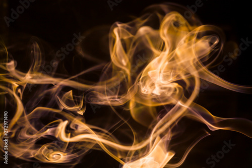Gold smoke movement on black background.