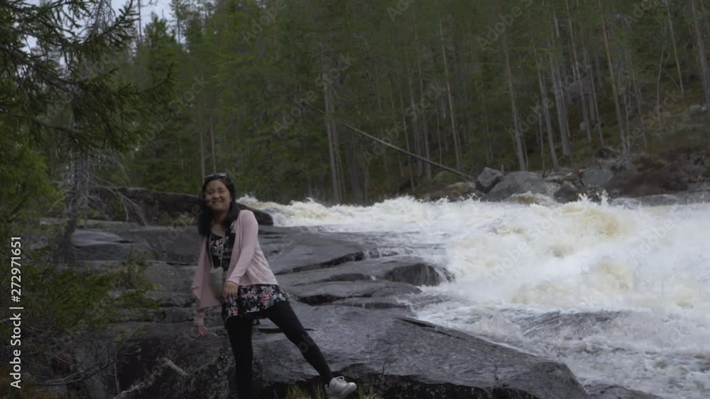 Happy girl playing by a waterfall. Slowmotion Happy girl playing by a waterfall. Slowmotion