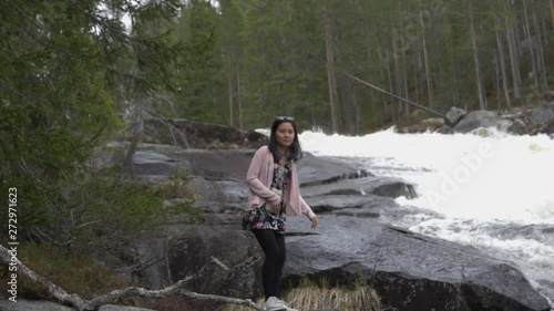 Girl by flowing river. Slowmotion photo