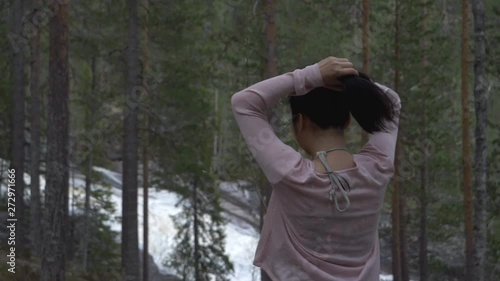 Girl playing with her hair in a forest, near a waterfall. slowmotion photo