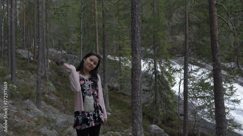 Girl waveing in the forest, near a waterfall. Slowmotion photo