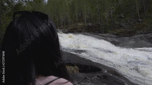 Girl looking at waterfall/river. slowmotion photo