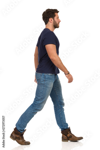 Walking Man In Blue T-shirt, Jeans And Boots