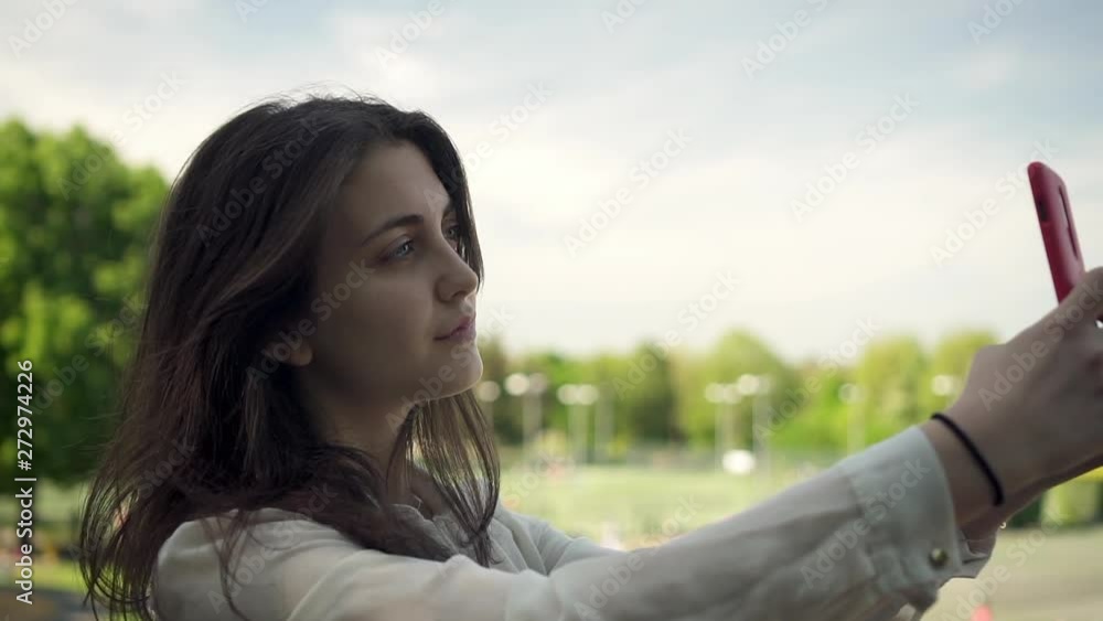 Young Italian Woman With Smartphone Taking Selfie Outdoors In a Park in London Young Italian Woman With Smartphone Taking Selfie Outdoors In a Park in London