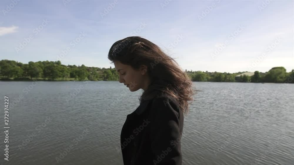 Sunset Portrait of an adorable and beautiful Italian model walking next to a lake, wearing a black coat, looking around, wandering and being free. Sunset Portrait of an adorable and beautiful Italian model walking next to a lake, wearing a black coat, looking around, wandering and being free.