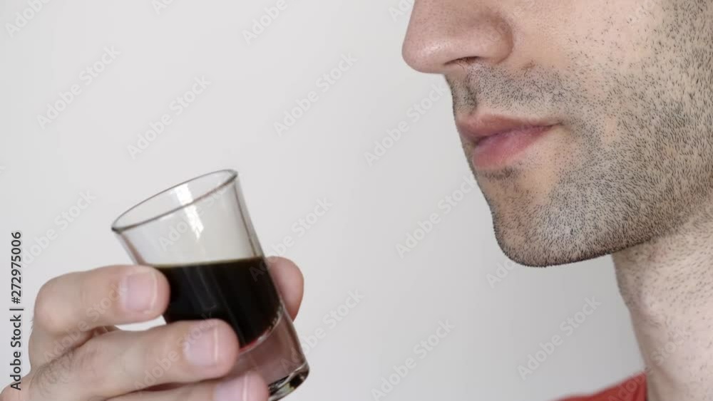 Close up shot of a coffee addict caucasian adult man with a stubble holding, smelling a shot of coffee in front of a white isolated background. Close up shot of a coffee addict caucasian adult man with a stubble holding, smelling a shot of coffee in front of a white isolated background.