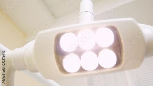 Fluorescent lamp for lighting in the dental office, hand movement.