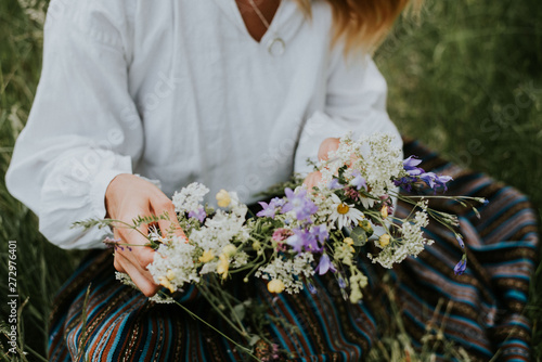 Folk girl in the midsummer making flower