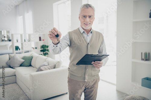 Close up photo friendly amazing he him his aged man arm hand pact realization keychain entrance specialist give buy buyer wear white shirt waistcoat pants comfy bright flat house living room indoors