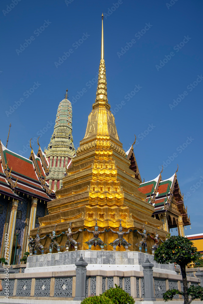 Golden chedi with ramakien figues around base and Royal Pantheon in background, Temple of the Emerald Buddha, Grand Palace, Bangkok, Thailand