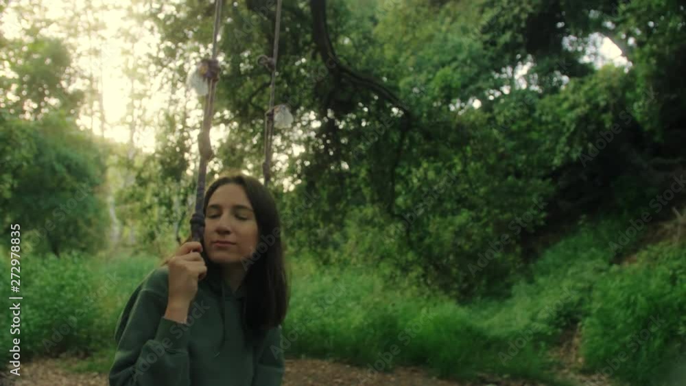 portrait shot of girl swinging on the swing in focus with
thoughtful facial expression in evening forest portrait shot of girl swinging on the swing in focus with
thoughtful facial expression in evening forest