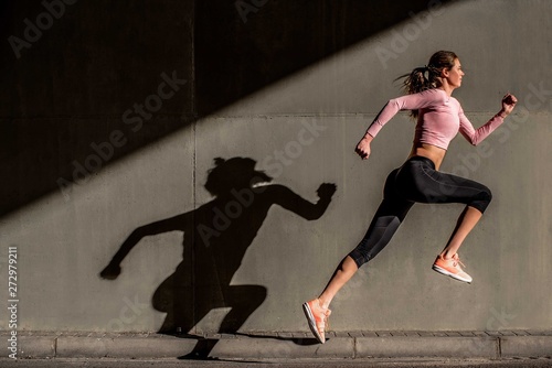 Young fit blonde woman jumping in the street