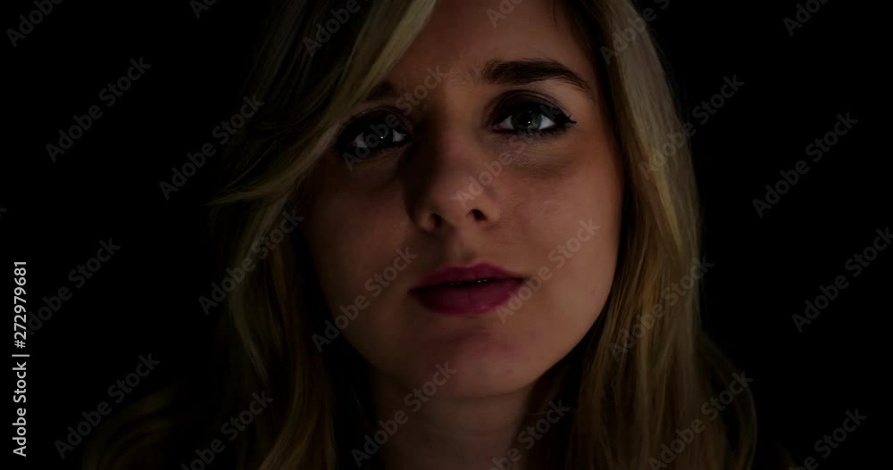Young woman makes many silly expressions to camera; close up; low key lighting. Young woman makes many silly expressions to camera; close up; low key lighting.