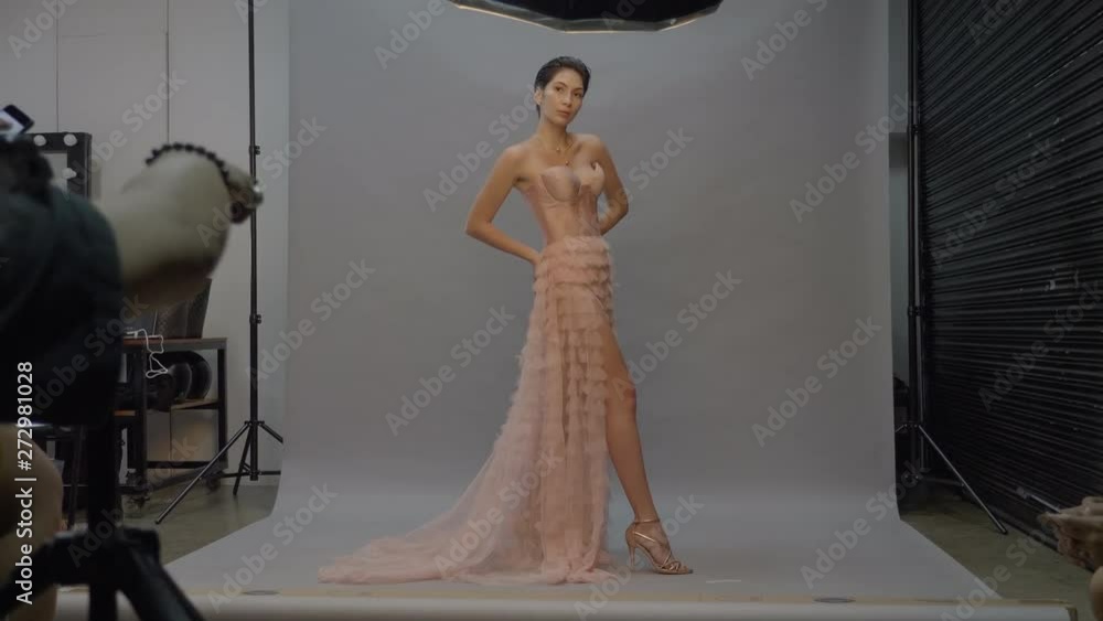 Model woman in pink dress posing for photographer in studio, Wide Shot ...