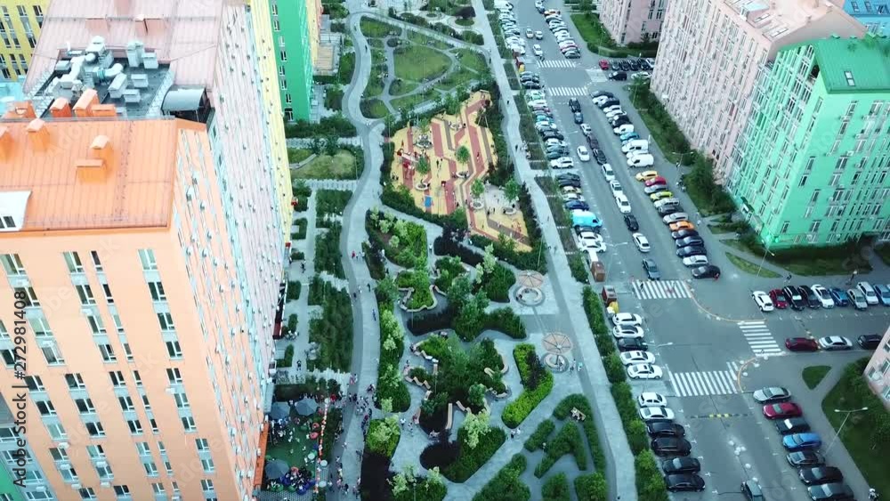 drone rises above a beautiful park in a residential area with colorful houses drone rises above a beautiful park in a residential area with colorful houses
