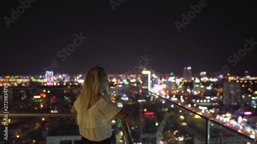 Girl looking at Da Nang city during night from a skybar in Vietnam photo