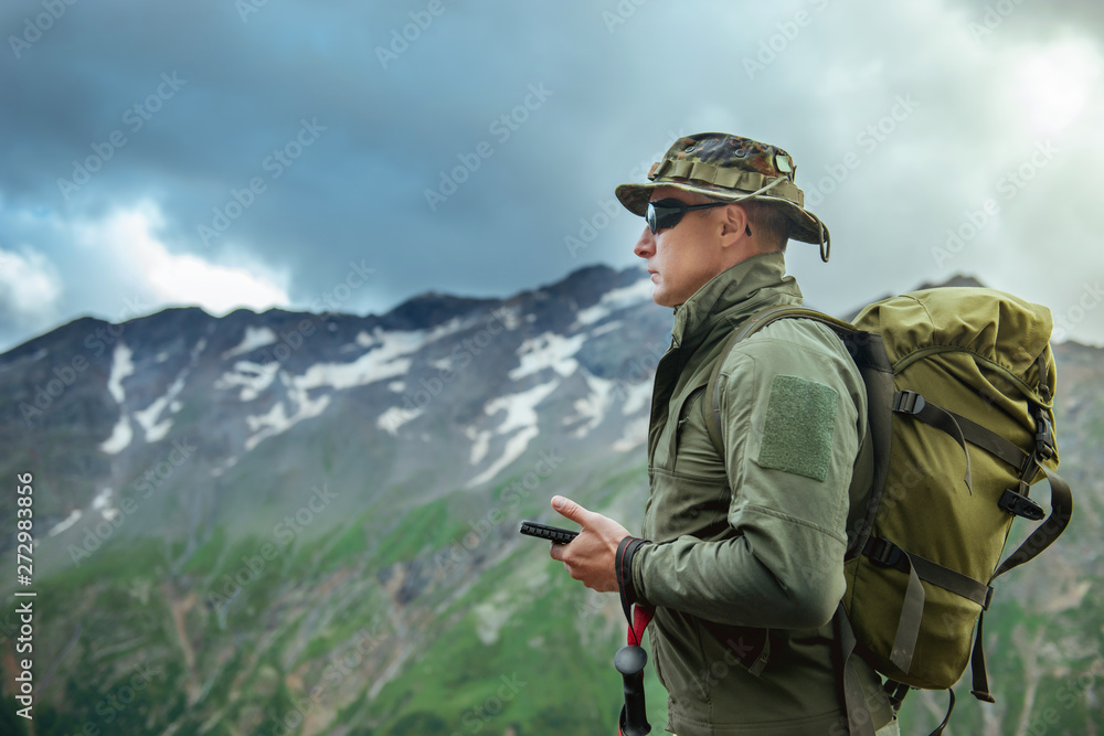 male tourist with a backpack looking at a navigator gps