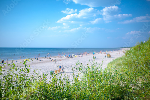Fototapeta Naklejka Na Ścianę i Meble -  People are relaxing on sandy beach of the Baltic sea. Seaside resort at warm summer day on Baltic sea in Lithuania, Europe.