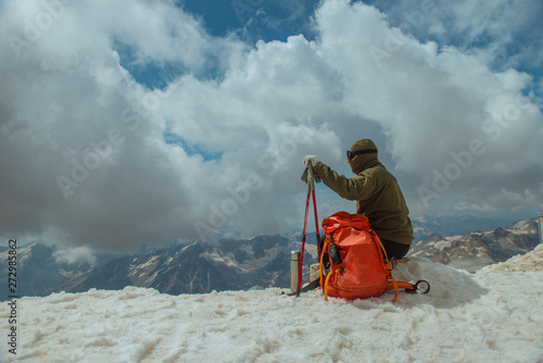 Сlimber reaches the top of mountain peak. Tourist climbs mount Elbrus, winter landscape