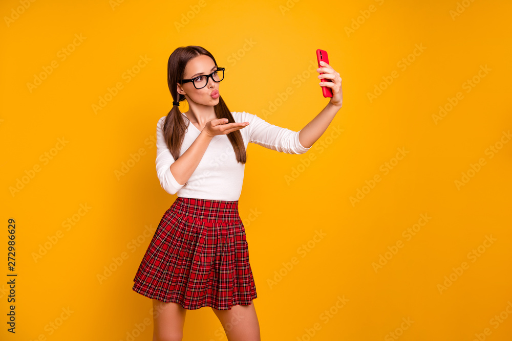 Portrait of nice-looking attractive lovely lovable tender winsome girl holding in hand camera making taking selfie video message isolated on bright vivid shine yellow background Portrait of nice-looking attractive lovely lovable tender winsome girl holding in hand camera making taking selfie video message isolated on bright vivid shine yellow background