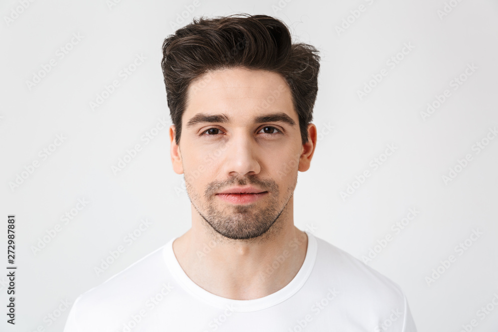 Fototapeta premium Serious concentrated young man posing isolated over white wall background.