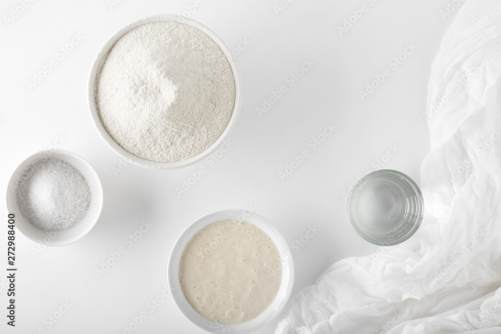 Ingredients for baking unleavened bread on a white table in a white bowl Ingredients for baking unleavened bread on a white table in a white bowl