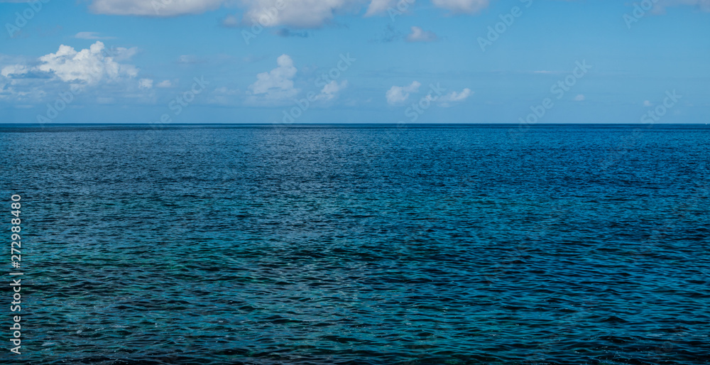Obraz premium Atlantic ocean seascape, with afternoon sunlight, blue sky and some clouds, Tenerife, Canary islands, Spain