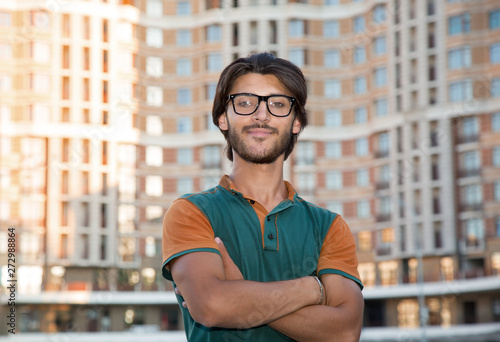 Portrait of a young man with glasses on the background of the city.