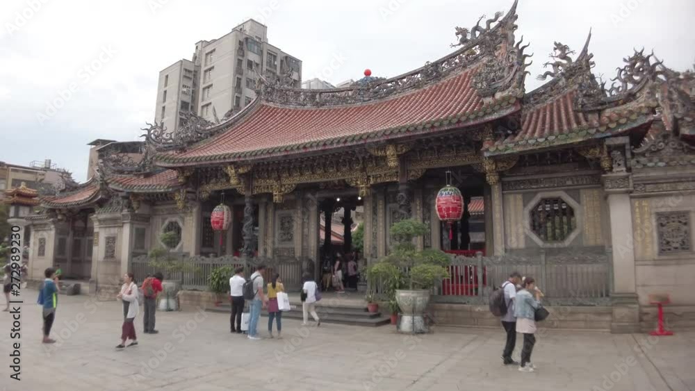 Time Lapse of the Lung Shan Temple in Taiwan. Tourists Walking in front of the Camera, as the Camera moves around the Temple Gates. Time Lapse of the Lung Shan Temple in Taiwan. Tourists Walking in front of the Camera, as the Camera moves around the Temple Gates.