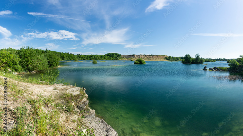 Sunny summer day at an abandoned quarry for the extraction of stone.