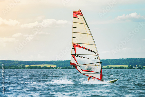 Windsurfer catches the wind and cuts the waves while driving fast © v_sot