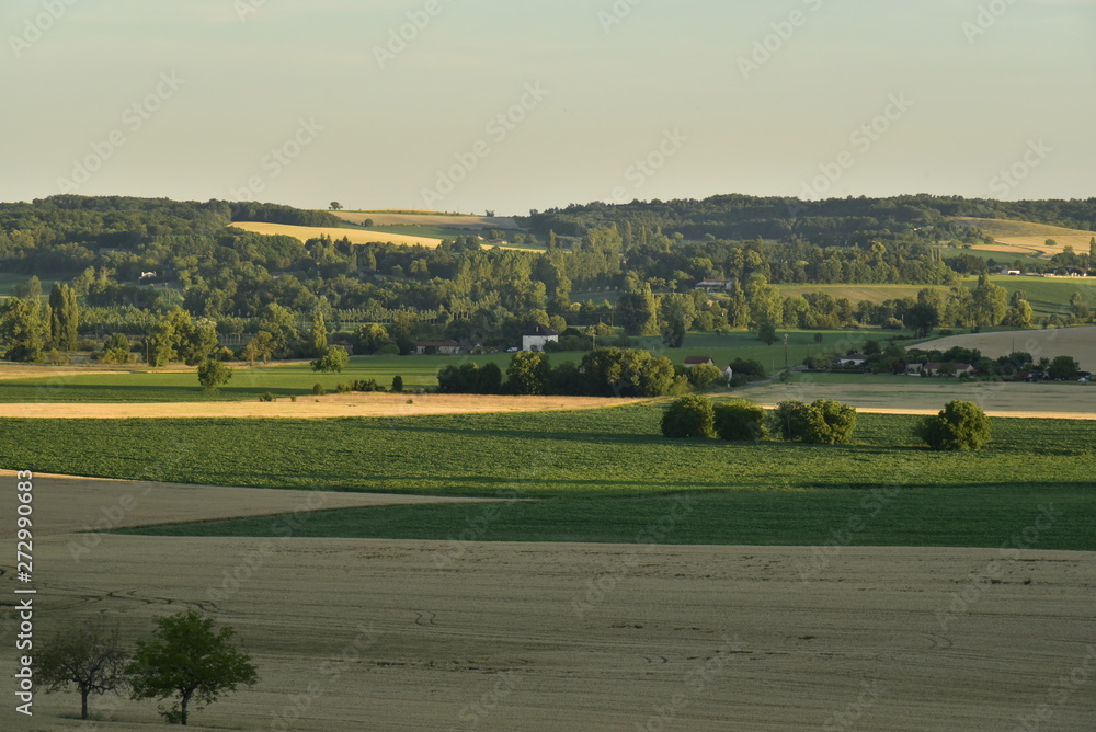 Lumière du coucher de soleil sur les champs et les collines boisées du Périgord Vert