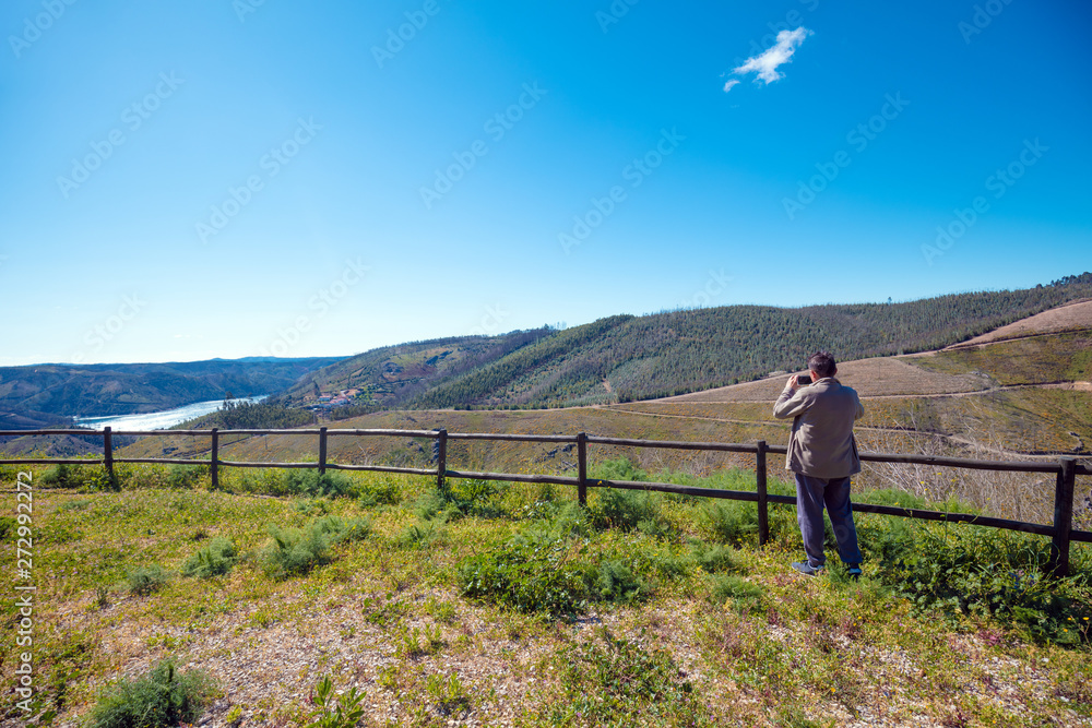 The resting place with a beautiful view of the mountain near the Zezere river. A man tourist takes a photo. Ferreira do Zêzere, Portugal