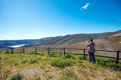 The resting place with a beautiful view of the mountain near the Zezere river. A man tourist takes a photo. Ferreira do Zêzere, Portugal photo