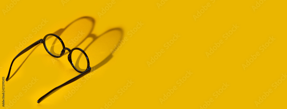 © AHOOLY - black round glasses on a yellow background with hard shadow and the inscription look © AHOOLY - black round glasses on a yellow background with hard shadow and the inscription look