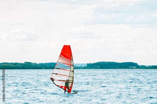 Windsurfer stands on the board and tries to catch a gust of wind