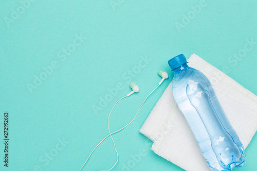 fitness concept with bottle of water, mobile phone with earphones