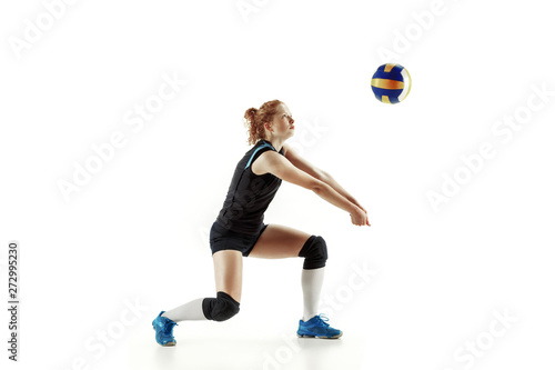 Young female volleyball player isolated on white studio background. Woman in sport's equipment and shoes or sneakers training and practicing. Concept of sport, healthy lifestyle, motion and movement.