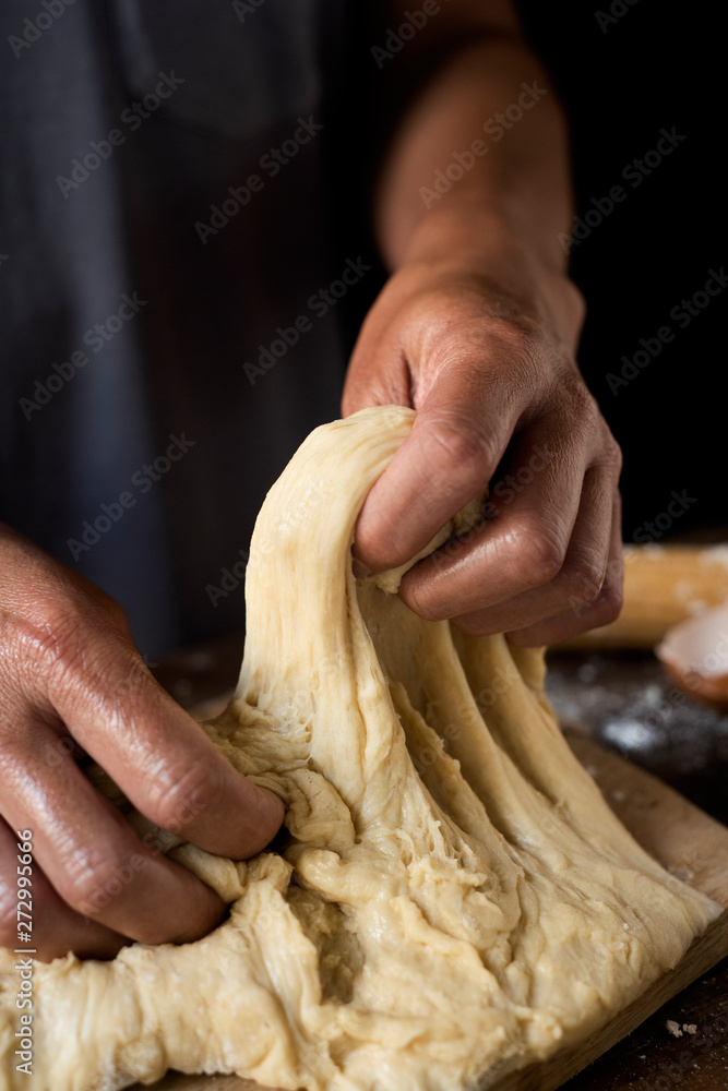 young man kneading a piece of dough