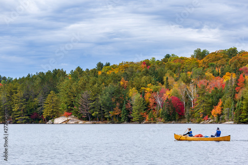 Canoë sur un lac devant une forêt colorée dans le parc Algonquin au Canada, Ontario