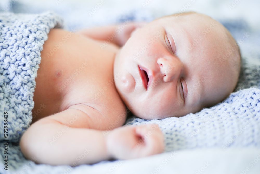Newborn baby boy sleeping in children's cot - closeup Newborn baby boy sleeping in children's cot - closeup