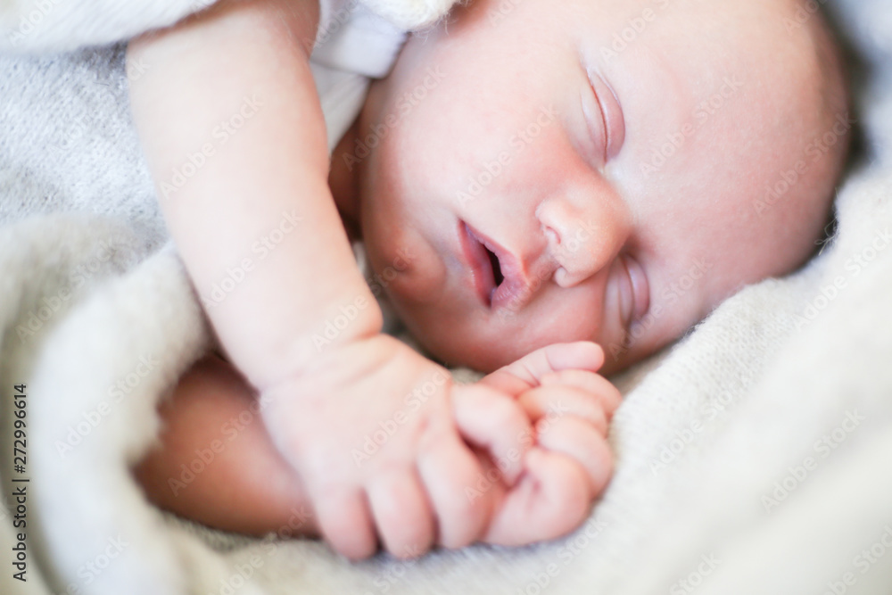 Newborn baby boy sleeping in children's cot - closeup Newborn baby boy sleeping in children's cot - closeup