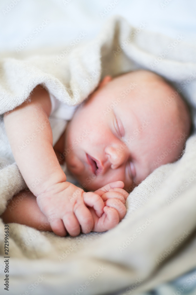 Newborn baby boy sleeping in children's cot - closeup Newborn baby boy sleeping in children's cot - closeup