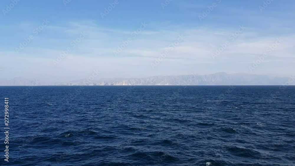View of the ocean and clouds in the sky. Blue sky with clouds in sunny weather over the ocean. Mountains and ocean on the horizon. View of the ocean and clouds in the sky. Blue sky with clouds in sunny weather over the ocean. Mountains and ocean on the horizon.