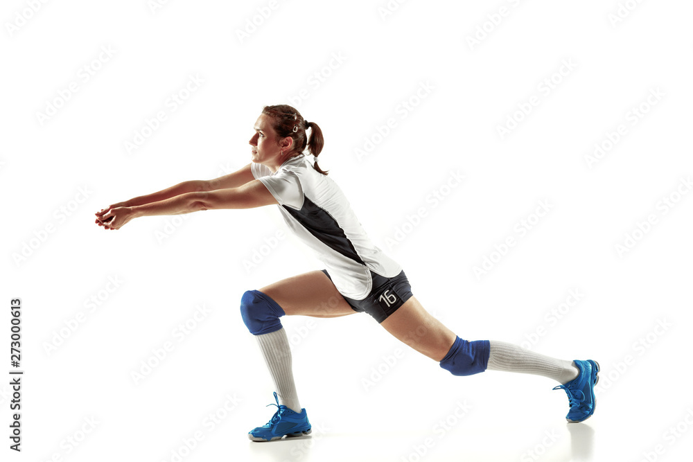 Young female volleyball player isolated on white studio background. Woman in sport's equipment and shoes or sneakers training and practicing. Concept of sport, healthy lifestyle, motion and movement.