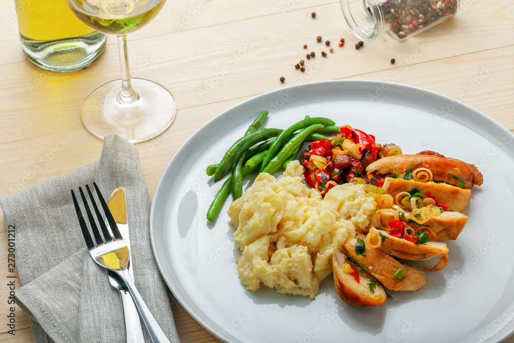 Roasted chicken breast fillet with mashed potato, green beans and vegetable sauce with white wine on a table. Traditional healthy food. Roasted chicken breast fillet with mashed potato, green beans and vegetable sauce with white wine on a table. Traditional healthy food.