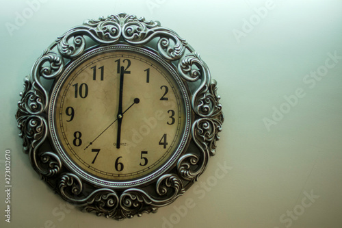 Ancient Wall Designer Wall Clock With Light Yellow Back Ground showing time 06.00 o'clock