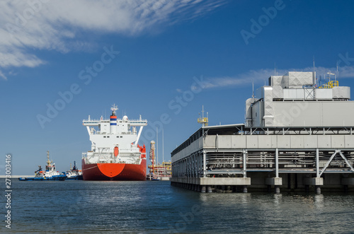 LNG TERMINAL AND GAS CARRIER - The big ship maneuvers in the mooring port at the wharf