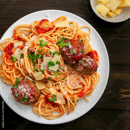 Italian meal made of pasta on a wooden table. Plate of traditional American spaghetti with meatballs and tomato sauce. Top view shot directly above.