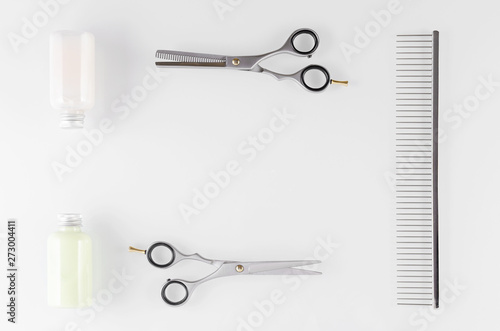 hair care equipment, shampoo and conditioner with comb and scissors on white